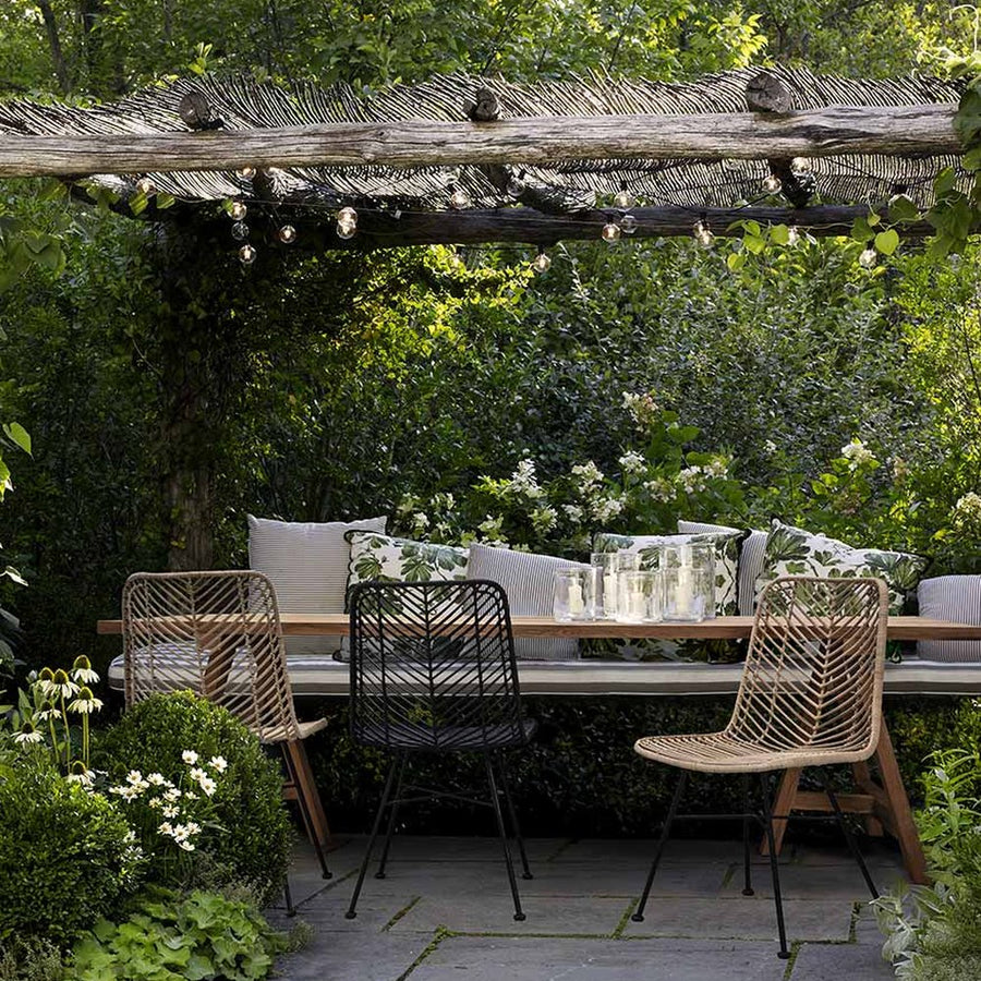 Kertben álló étkezőasztal kortárs design rattan étkezőszékekkel.