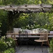 Kertben álló étkezőasztal kortárs design rattan étkezőszékekkel.