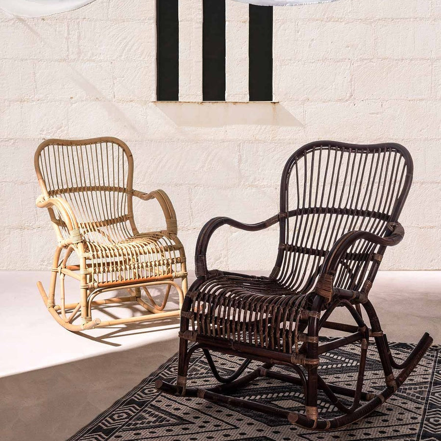 Napsütötte, vászonvitorlák alatt álló skandináv stílusú rattan hintaszékek.