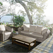 Tengerparti teraszon álló mediterrán stílusú rattanfotel és kanapé.