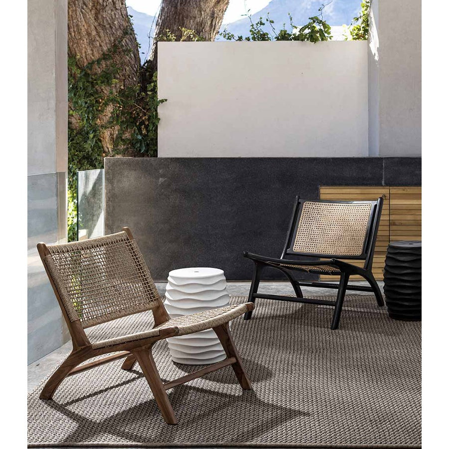 Kortárs, fedett teraszon álló teakfa pihenőszékek.