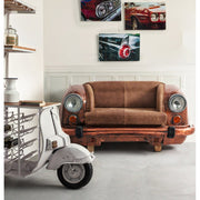 Loft stílusú nappaliban felállított bronz színű autófront kanapé, bőr üléssel és működő autólámpákkal.