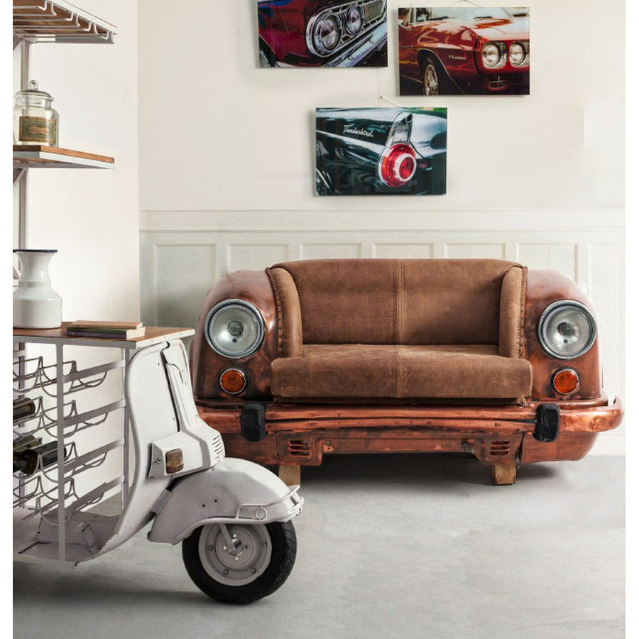 Loft stílusú nappaliban felállított bronz színű autófront kanapé, bőr üléssel és működő autólámpákkal.