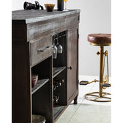 Fából készült bárpult mellett álló ipari stílusú pedálos bárszék.