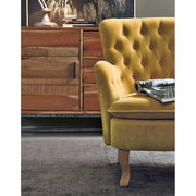 Lost stílusú nappaliban, komód előtt álló mustársárga színű vintage stílusú fotel.