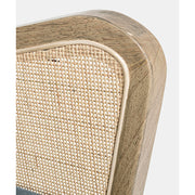 A retró stílusú klubfotel rattannal átszőtt karfája. 