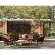 Árnyékos kültéri teraszon álló négydarabos skarlátvörös színű design kerti garnitúra.