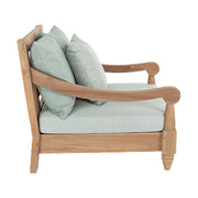 Keleti stílusú teakfa fotel oldala zöldeskék ülő- és hátpárnákkal.