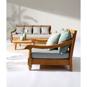 Keleti stílusú teakfa fotel zöldeskék ülő- és hátpárnákkal fedett teraszon.