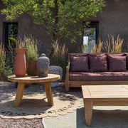 Mediterrán udvaron álló bordó színű teakfa Bali kanapé és dohányzóasztal.