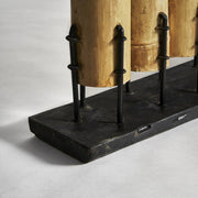 A trópusi stílusú, natúr színű térelválasztó fekete színű, fém talapzatának részlete..