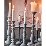 Vintage stílusú gyertyatartókon lobogó sztearin alapú gyertyák.