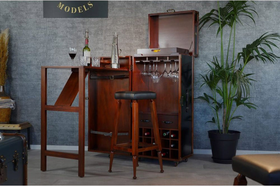Loft stílus nappaliban felállított utazóláda bárszekrény italokkal és poharakkal.