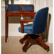 Közlekedőben álló bársonyberakásos panellel rendelkező íróasztal székkel.