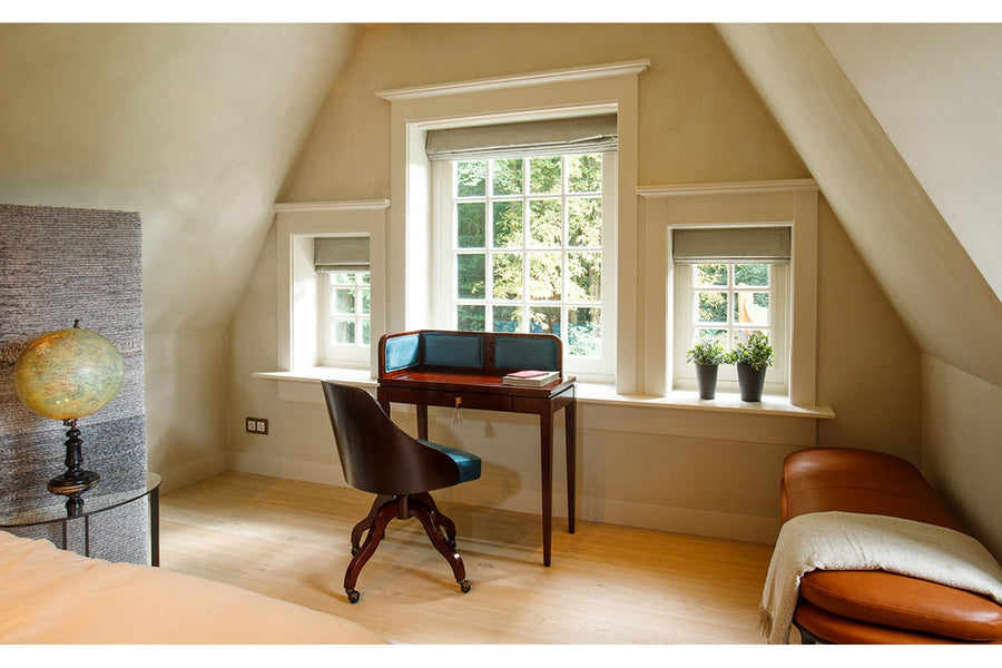 Hálószoba ablaka előtt álló bársonyberakásos panellel rendelkező íróasztal.