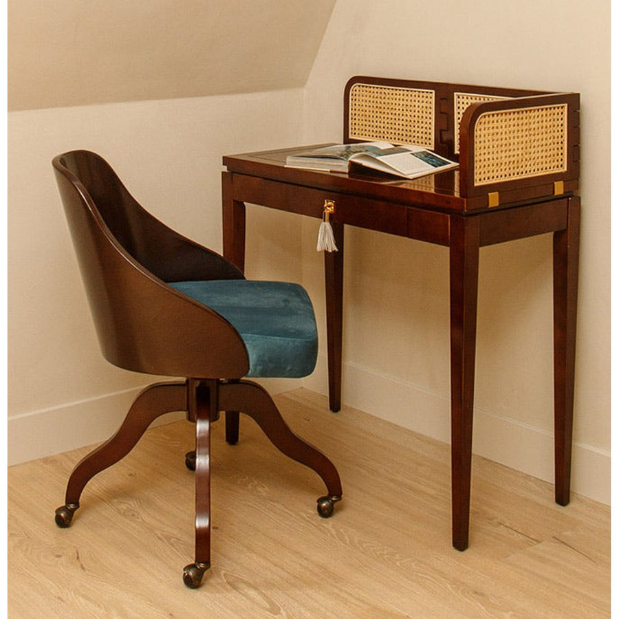 Szoba sarkában álló rattanberakásos árnyékoló panellel rendelkező íróasztal székkel.