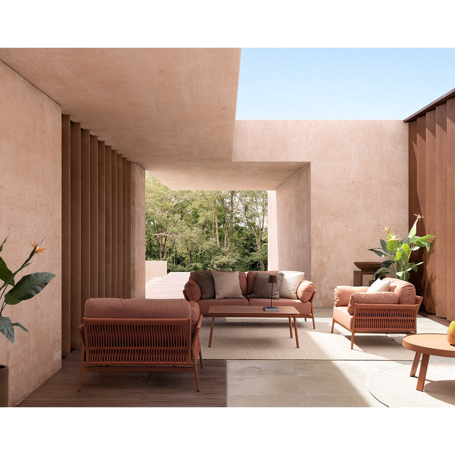 Fedett, mediterrán teraszon álló kortárs, korallszínű kanapé és fotelek.