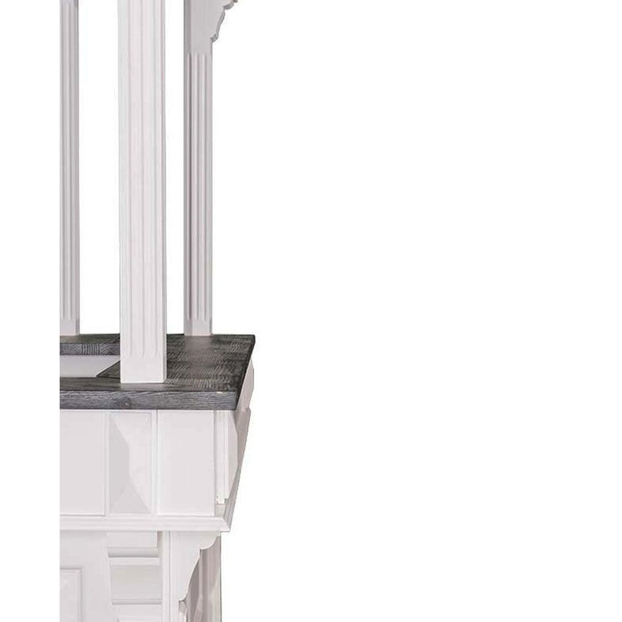 Részletfotó a fehér színű, fenyőfából készült bárpult sarokelemről öt oszlopon álló galériával.