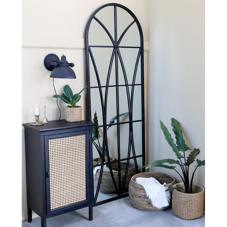 Loft stílusú szobában, komód valamint kosarak melett álló loft stílusú, fekete színű falitükör.