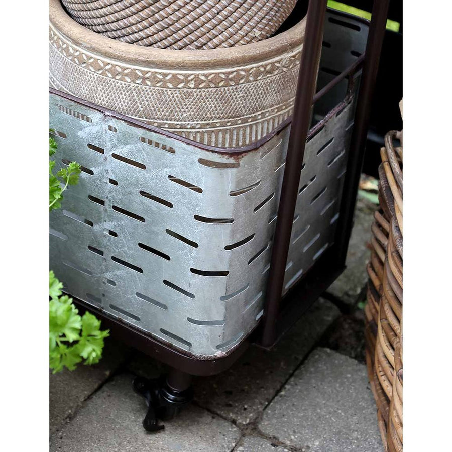 Hangulatkép: a görgős virágállvány egy teraszon, rajta növények, kaspók, lámpások