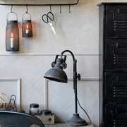 Ipari stílusú dolgozószoba asztallal, fiókos szekrénnyel és asztali lámpával.