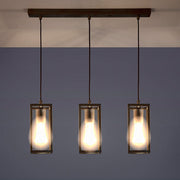 Ipari stílusú, anikolt sárgaréz színű réz függeszték három izzófoglalattal működés közben.