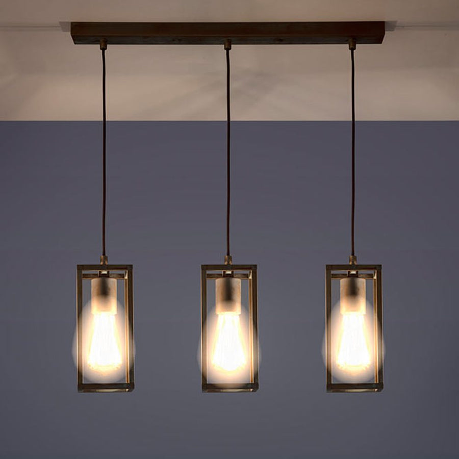 Ipari stílusú, anikolt sárgaréz színű réz függeszték három izzófoglalattal működés közben.