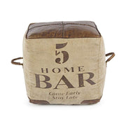 Újrahasznosított vászonból és bőrből készült kocka alakú puff.