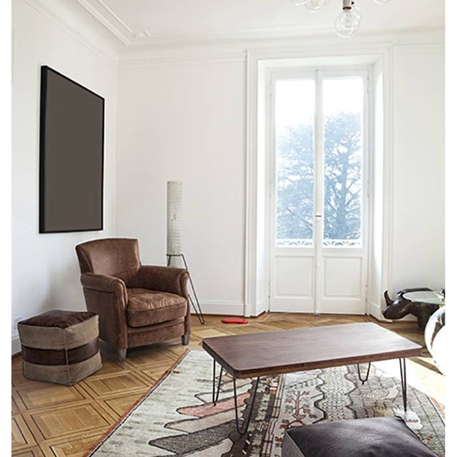 Loft stílusú nappali bőrfotellel és bőrből készült puffal.