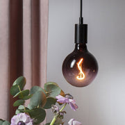 Cserepes mályva virág felett függesztéken lógó dekoráció izzó.