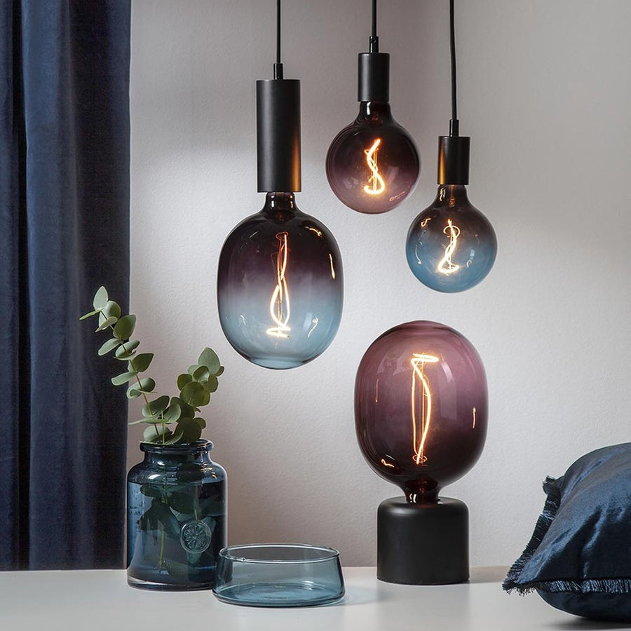 A Colourmix kollekció két méretben kapható izzó kék és mályva színekben függesztékekben és asztali foglalatban.
