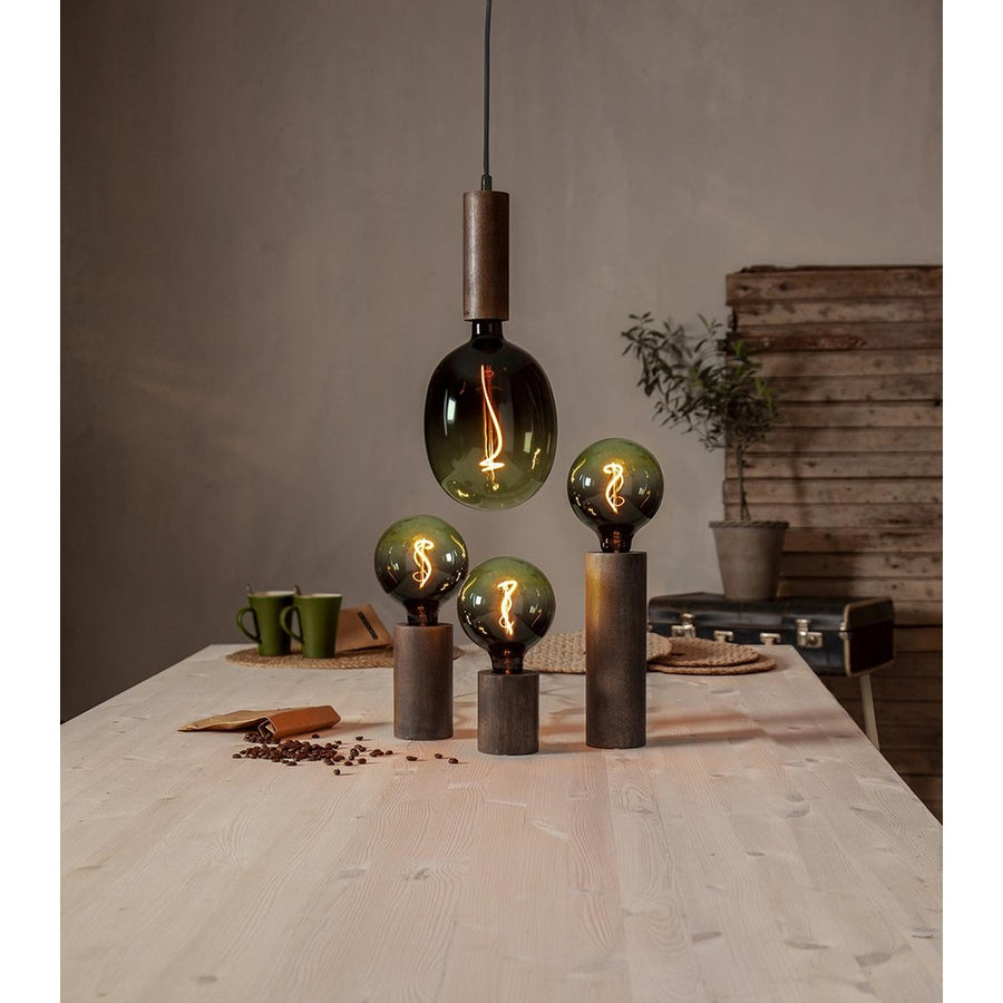 A Colourmix termékcsalád zöld izzói. Három izzó asztali dekorfoglalatban áll, a harmadik egy függesztéken lóg.