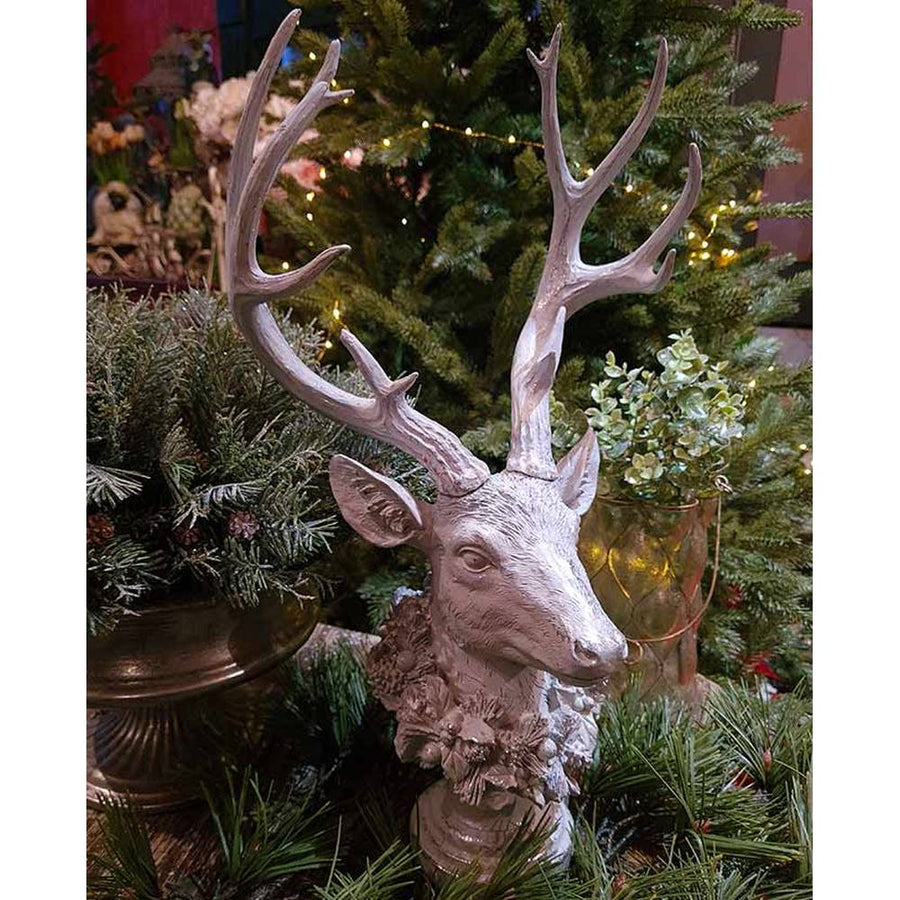 Prémium kategóriás, részletgazdagon kivitelezett glitteres karácsonyi szarvas koszorúval a nyakában fenyők között 