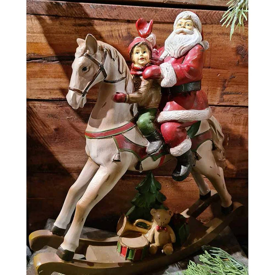 Vintage stílusú, karácsonyi hintaló Télapóval és kisfiúval barna színű deszkafal előtt