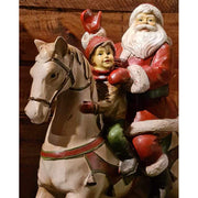 Vintage stílusú, karácsonyi hintaló Télapóval és kisfiúval barna színű deszkafal előtt