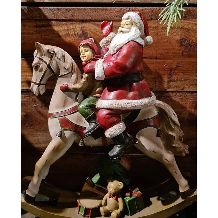 Vintage stílusú, karácsonyi hintaló Télapóval és kisfiúval barna színű deszkafal előtt