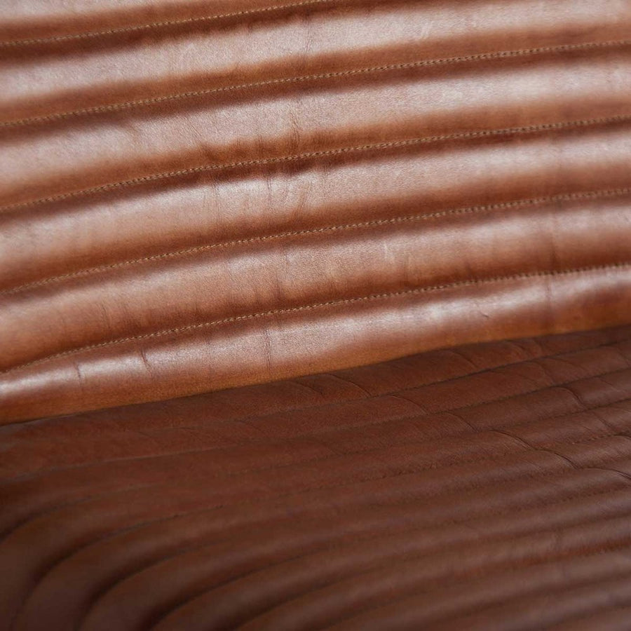 Loft stílusú, retró jegyeket magán viselő bőrfotel.