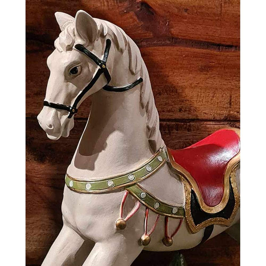 Vintage stílusú, 29,5 cm hosszú, fehér és piros színű karácsonyi hintaló ajándékokkal barna deszkafal előtt