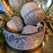 Aranyszínű dombormintával díszített, modern, glamour stílusú kerámia arany tál, aranyszínű makkokkal, fém tálcán.