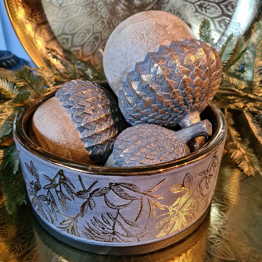 Aranyszínű dombormintával díszített, modern, glamour stílusú kerámia arany tál, aranyszínű makkokkal, fém tálcán.