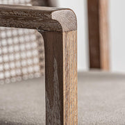 Art Deco stílusjegyeket mutató, kőrisfából és rattanból készült kortárs karosszék, bézs színű vászonnal kárpitozott ülőfelülettel.