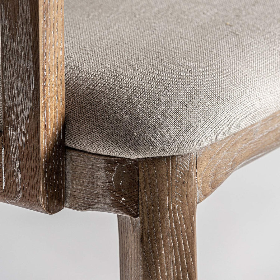 Art Deco stílusjegyeket mutató, kőrisfából és rattanból készült kortárs karosszék, bézs színű vászonnal kárpitozott ülőfelülettel.