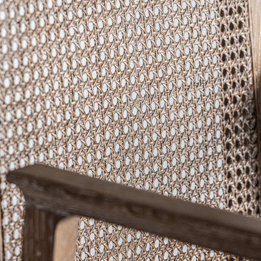 Art Deco stílusjegyeket mutató, kőrisfából és rattanból készült kortárs karosszék, bézs színű vászonnal kárpitozott ülőfelülettel.