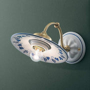 Festett motívumokkal díszített, mázas kerámiából és fémből készült kézműves falilámpa.