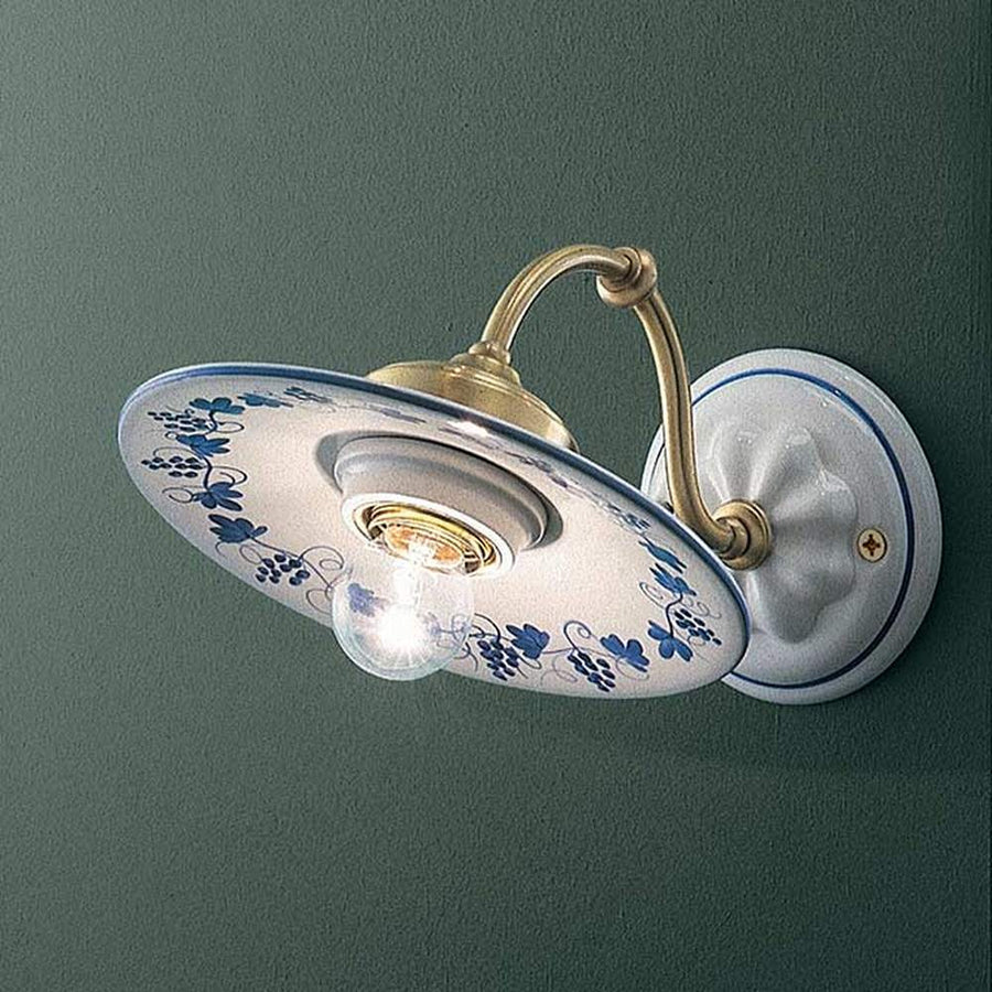 Festett motívumokkal díszített, mázas kerámiából és fémből készült kézműves falilámpa.