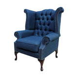 Kék színű vászon szövettel kárpitozott Chesterfield szárnyas fotel.