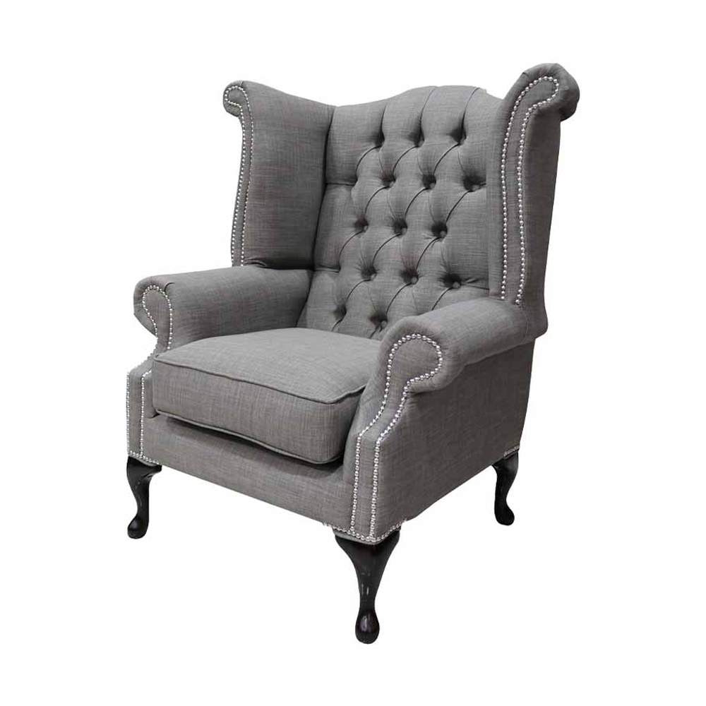 Palaszürke színű vászonnal kárpitozott Chesterfield fotel.
