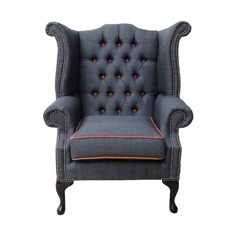 Narancssárga színű szegélyű, sötétszürke színű vászonnal kárpitozott Chesterfield fotel.