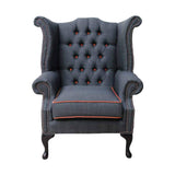 Narancssárga színű szegélyű, sötétszürke színű vászonnal kárpitozott Chesterfield fotel.