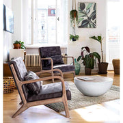 Loft stílusú nappaliban álló újrhasznosított fából készült félgömb alakú dohányzóasztal.